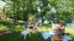 Spelende en picknickende mensen op een grasveld aan het water