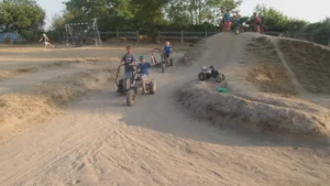 Spelende kinderen op skelters en op een voetbalveldje