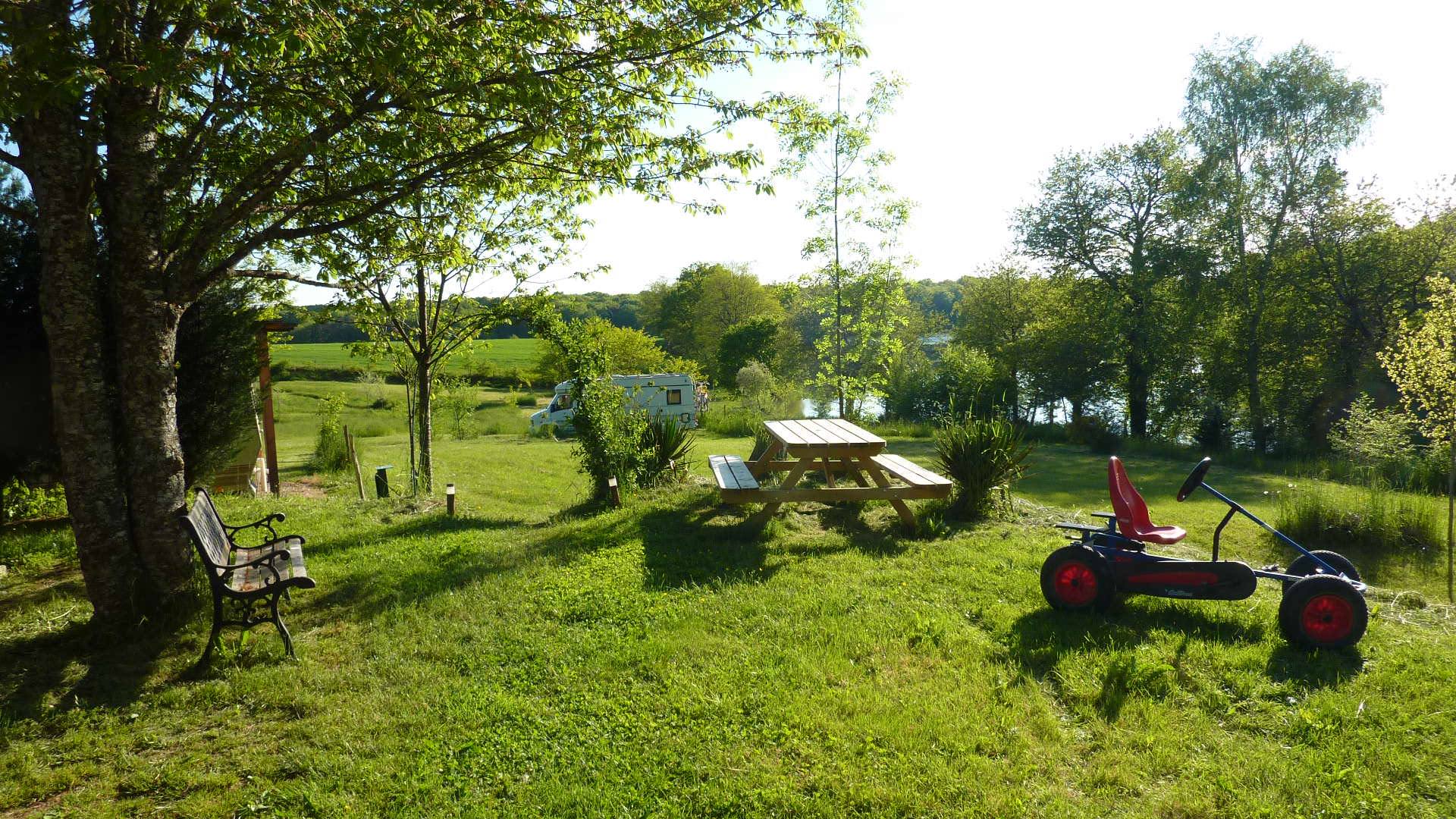 Picknicktafel en skelter op een veldje met uitzicht op het meer