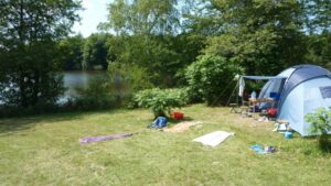 Tent in de zon tussen de bomen aan het water